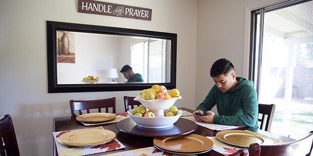 Angel Diaz sits at a table in the home he recently purchased. (Photo by Andres Guerra Luz/Cronkite ...
