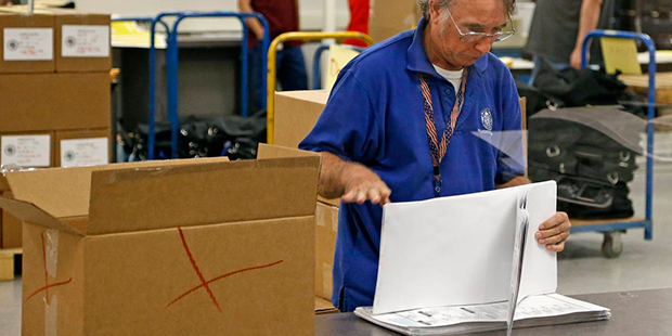 An Arizona elections official at the Maricopa County Recorder's Office gets ready to box up recount...