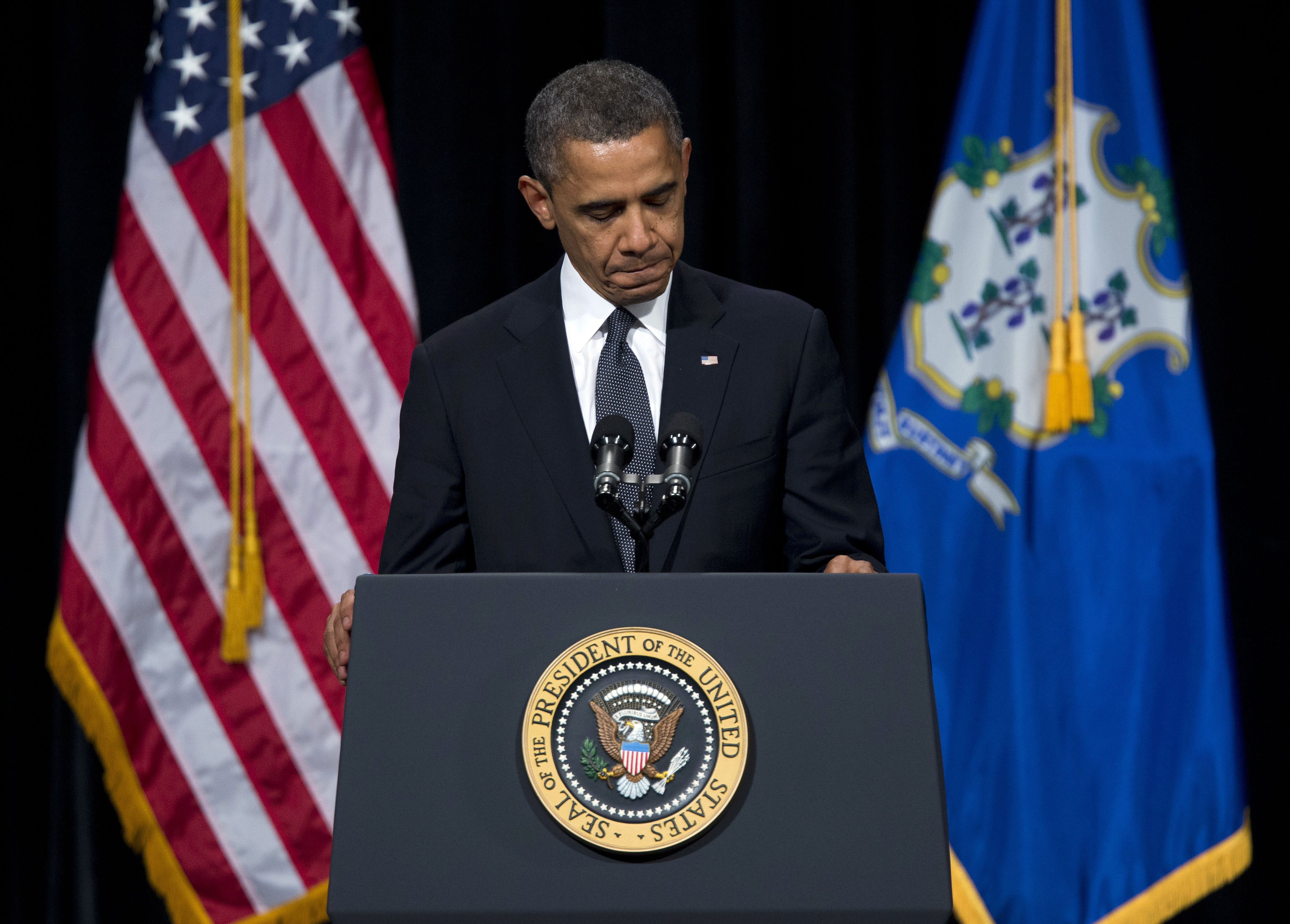 President Barack Obama pauses during a speech at an interfaith vigil for the victims of the Sandy Hook Elementary School shooting on Sunday, Dec. 16, 2012 at Newtown High School in Newtown, Conn. A gunman walked into Sandy Hook Elementary School on Friday and opened fire, killing 26 people, including 20 children. (AP Photo/Evan Vucci)