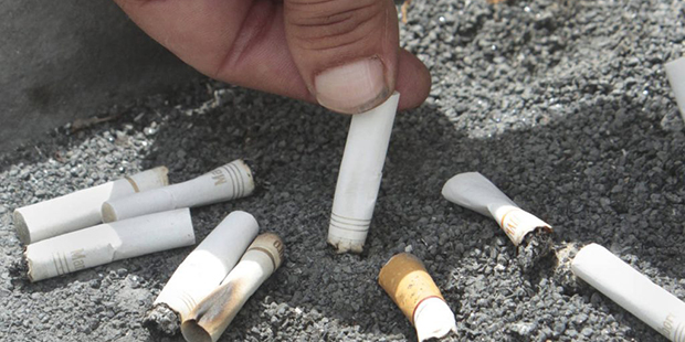 FILE - In this June 22, 2012, file photo, a smoker snuffs out a cigarette at the Capitol in Sacrame...