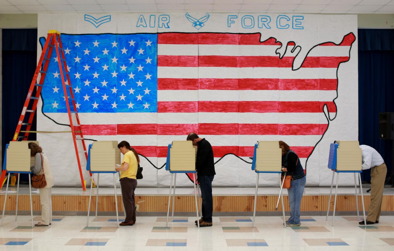 Voters cast their ballots on Election Day in front of a stage decoration for a Veterans Day event at Robious Elementary School in Midlothian, Va., Tuesday, Nov. 4, 2014. (AP Photo/Richmond Times-Dispatch, Daniel Sangjib Min)