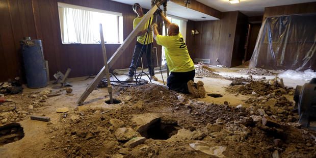 Corey Grotefendt, left, and colleague Don Baykowski drive pears into the ground in an effort to sta...