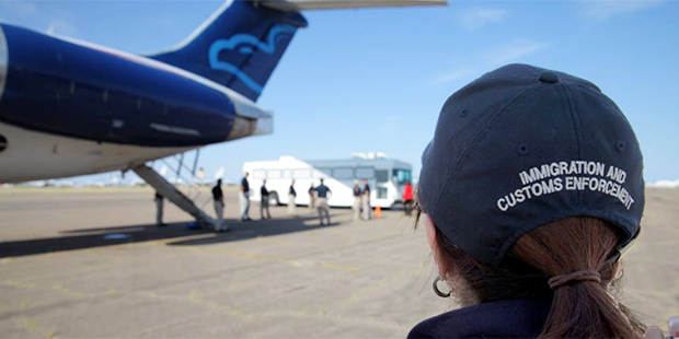 An ICE agent looks on to an airplane. (Facebook photo)...