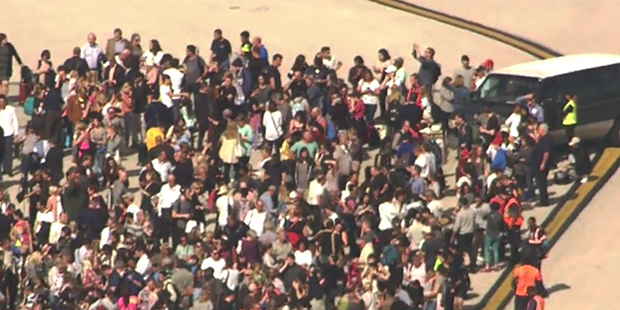 Passengers stand on the tarmac at Fort Lauderdale-Hollywood International Airport after a shooting ...