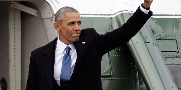 Former President Barack Obama waves as he boards a Marine helicopter during a departure ceremony on...