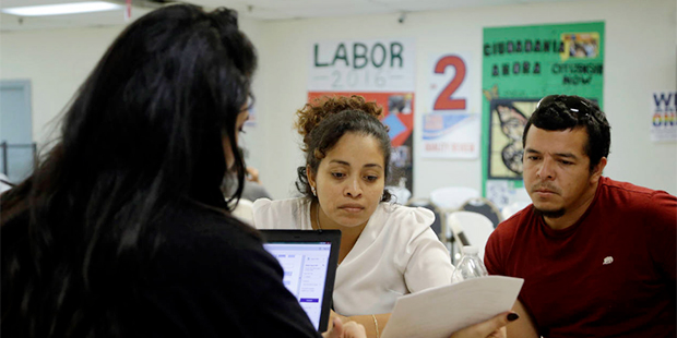Jacquelinne Perez, left, and her husband Miguel Obando, right, both of Nicaragua, go through their ...