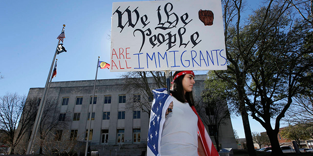 High school senior Vicky Sosa holds a sign outside the Grayson County courthouse in downtown Sherma...