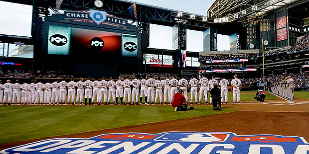 The Colorado Rockies and Arizona Diamondbacks line up during the National Anthem prior to a basebal...