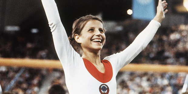 In this August 1972 file photo, Olga Korbut of Russia, throws up her arms in joy after winning the ...