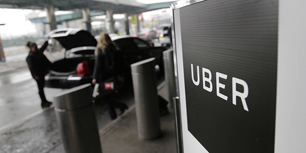 File- In this March 15, 2017, file photo, a sign marks a pick-up point for the Uber car service at ...