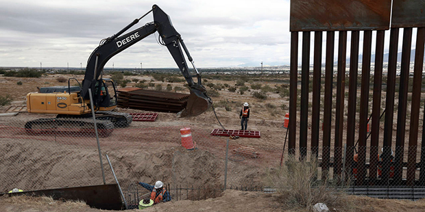 FILE - In this Nov. 10, 2016, file photo, workers continue work raising a taller fence in the Mexic...