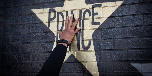 A fan touches the Prince star on the exterior of the building at First Avenue to remember him on th...