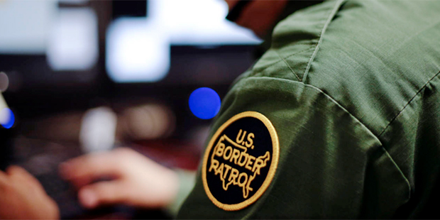 File- In this June 5, 2014 file photo, a Border Patrol agent uses a headset and computer to conduct...