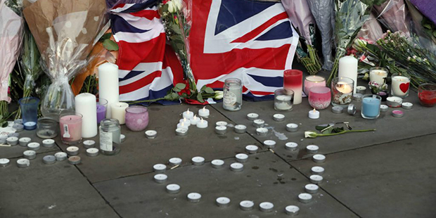 Flowers and candles are seen after a vigil in Albert Square, Manchester, England, Tuesday May 23, 2...