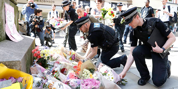 Police offices add to the flowers for the victims of Monday night pop concert explosion, in St Ann'...