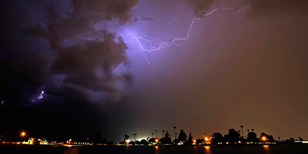 Lightning streaks across the night sky as a monsoon storm sweeps through the Phoenix metro area Wed...