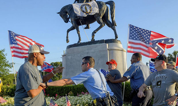 New Orleans Police separate two men after the two tussled, at the Gen. P.G.T. Beauregard monument i...