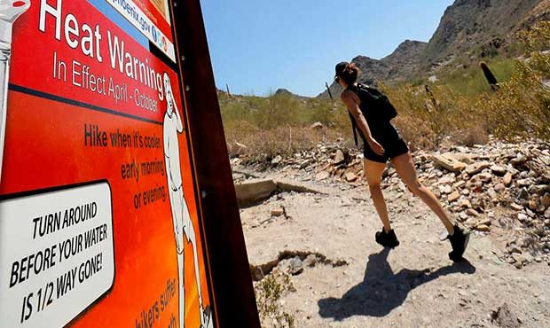 Signs warning of extreme heat are placed on a trailhead, Wednesday, June 22, 2016, at Piestewa Peak...