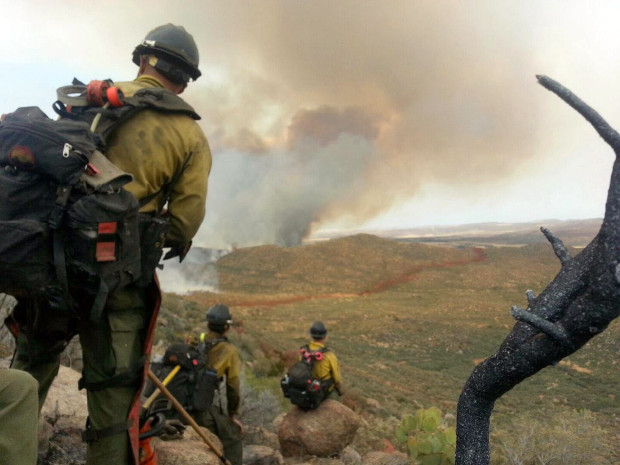 In this photo shot by firefighter Andrew Ashcraft, members of the Granite Mountain Hotshots watch a growing wildfire that later swept over and killed the crew of 19 firefighters near Yarnell, Ariz., Sunday, June 30, 2013. Ashcraft texted the photo to his wife, Juliann, but died later that day. (AP Photo)