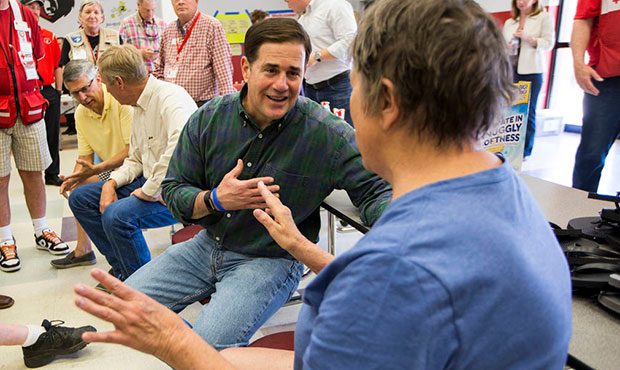 Arizona Gov. Doug Ducey speaks with Jean Wilson, a 71-year-old evacuee from the community of Pine F...