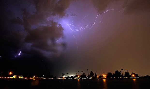 Lightning streaks across the night sky as a monsoon storm sweeps through the Phoenix metro area Wed...