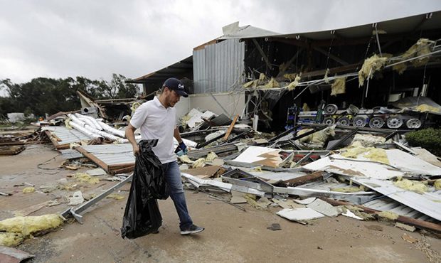 Miguel Debernardis cleans up debris in the aftermath of Hurricane Harvey Saturday, Aug. 26, 2017, i...