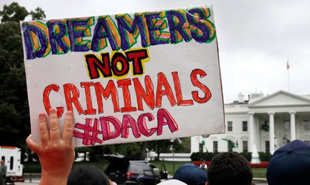A woman holds up a signs in support of the Obama administration program known as Deferred Action fo...