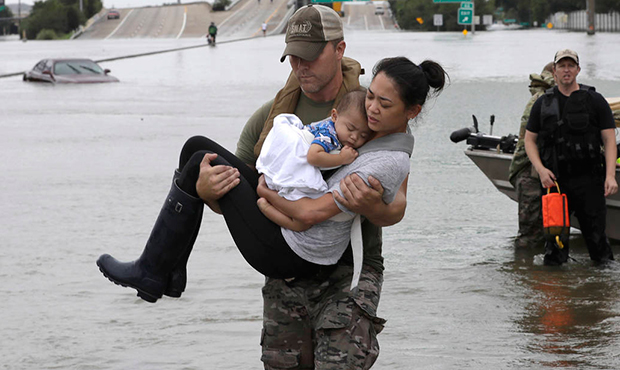 Houston Police SWAT officer Daryl Hudeck carries Connie Pham and her 13-month-old son Aiden after r...