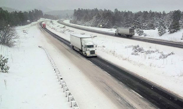 Trucks maneuver along a single, cleared lane in each direction of Interstate 40 west of Flagstaff, ...