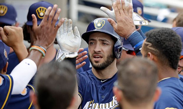 Milwaukee Brewers' Ryan Braun is congratulated after scoring during the first inning of a spring tr...
