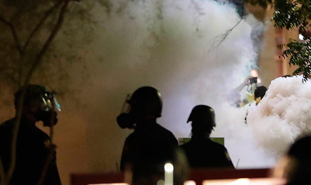 Smoke billows after Phoenix police used tear gas outside the Phoenix Convention Center, Tuesday, Au...