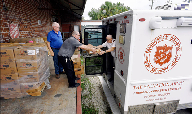 Carl Lundy and Daryl Hettick, maintenance workers from the Salvation Army, hand area commander Majo...