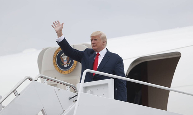 President Donald Trump waves as he arrives on Air Force One at Andrews Air Force Base, Md., Monday,...