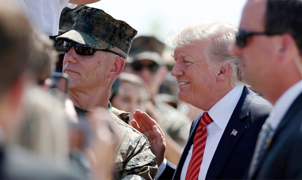 President Donald Trump poses for a picture as he greets U.S. Marines before he departs Tuesday, Aug...