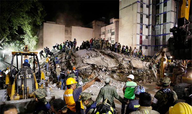 Rescue workers search for people trapped in a collapsed building in the Piedad Narvarte neighborhoo...