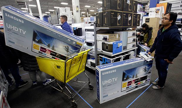 FILE - In this Thursday, Nov. 23, 2017, file photo, people wait to pay for televisions as they shop...