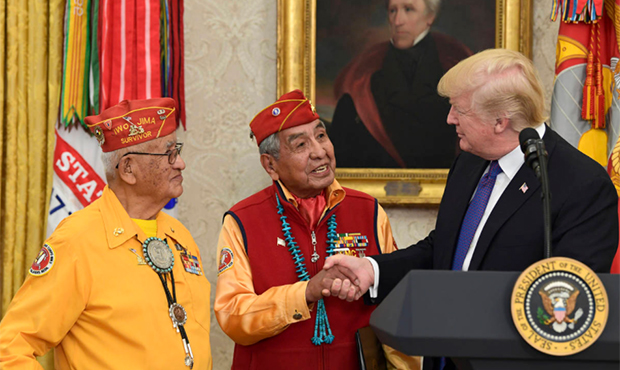 President Donald Trump, right, meets with Navajo Code Talkers Peter MacDonald, center, and Thomas B...