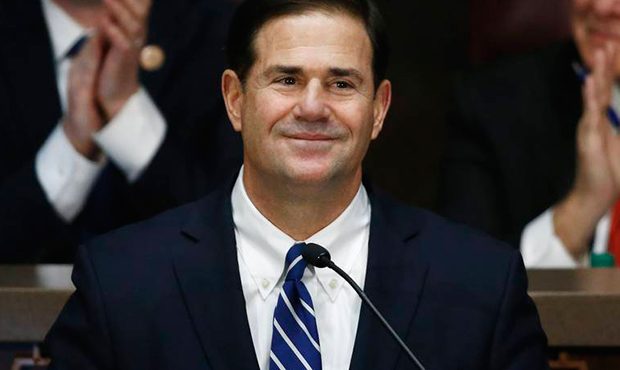Arizona Republican Gov. Doug Ducey, middle, pauses as he gives his state of the state address as he...