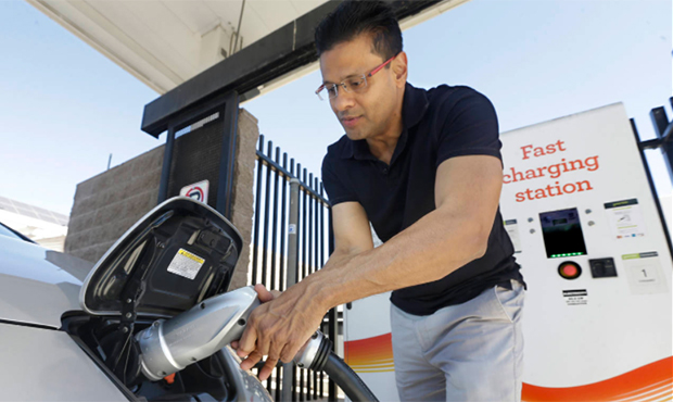 FILE - In this Thursday, Sept. 17, 2015 file photo, Darshan Brahmbhatt, plugs a charger into his el...