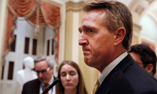 Sen. Jeff Flake, R-Ariz., listens to a question from a reporter before a Senate procedural vote to ...