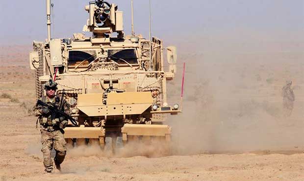 Then-U.S. Army Staff Sgt. Nicholas Amsberry ground guides a mine-resistant, ambush-protected vehicl...