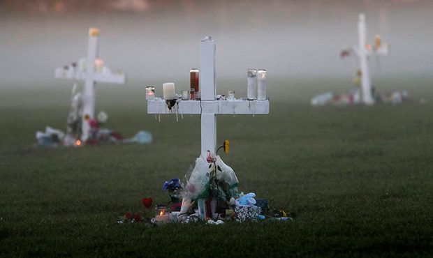 An early morning fog rises where 17 memorial crosses were placed, for the 17 deceased students and ...
