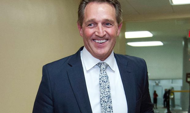 Sen. Jeff Flake, R-Ariz., walks to the senate chamber for early morning votes, Friday, Feb. 9, 2018...