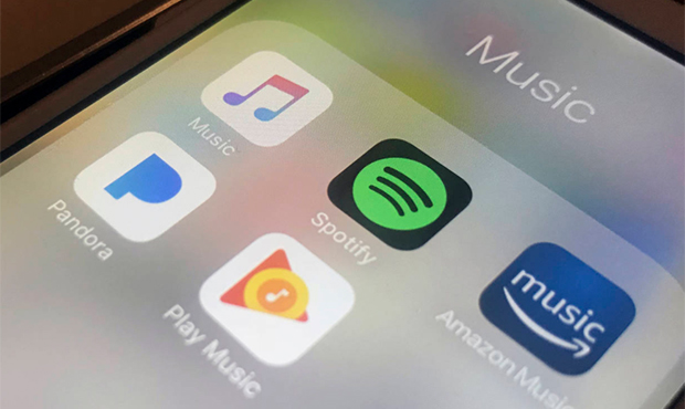 This Sunday, Jan. 28, 2018, photo shows music streaming apps clockwise from top left, Apple, Spotif...
