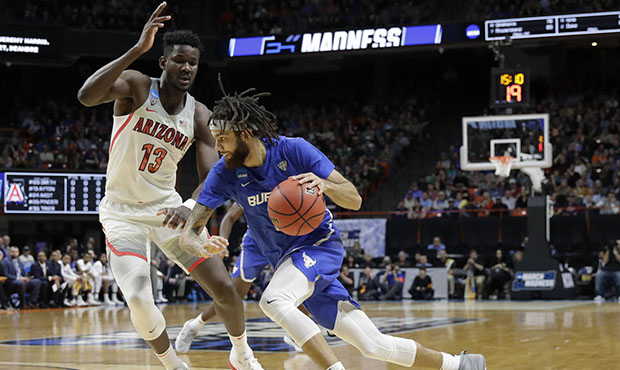 Buffalo guard Jeremy Harris, right, drives around Arizona forward Deandre Ayton (13) during the fir...