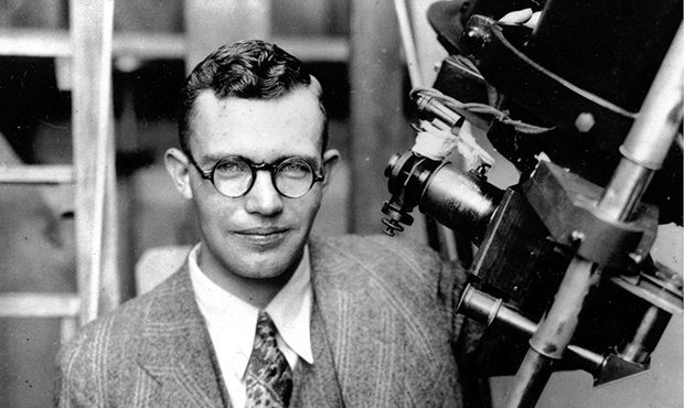 FILE - In this 1931 file photo, Clyde Tombaugh poses with the telescope through which he discovered...