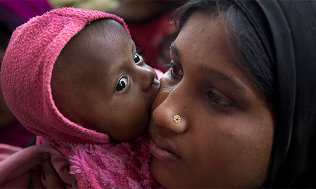 In this Saturday, Jan. 27, 2018, photo, a newly arrived Rohingya refugee child licks the cheek of h...