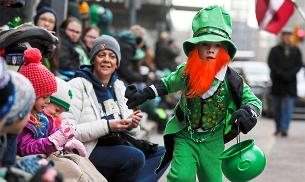 Brady Kuntz, 6, sprints down the street handing out candy in a leprechaun costume during the Pittsb...