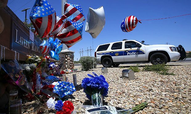 A Phoenix Police Department squad SUV parks next to a makeshift memorial to honor slain Phoenix Pol...