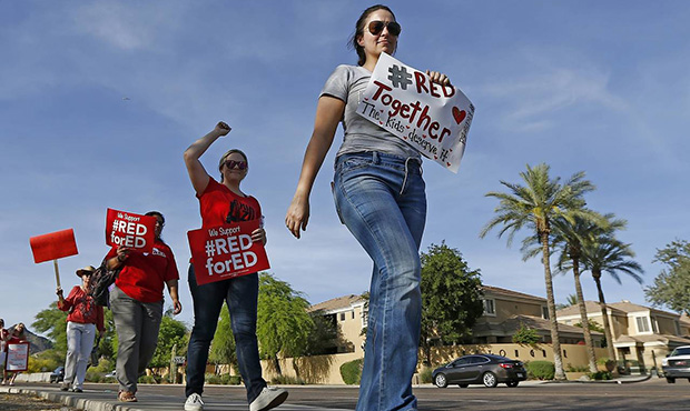 Arizona teachers march in protest of their low pay and school funding in front of a local radio sta...